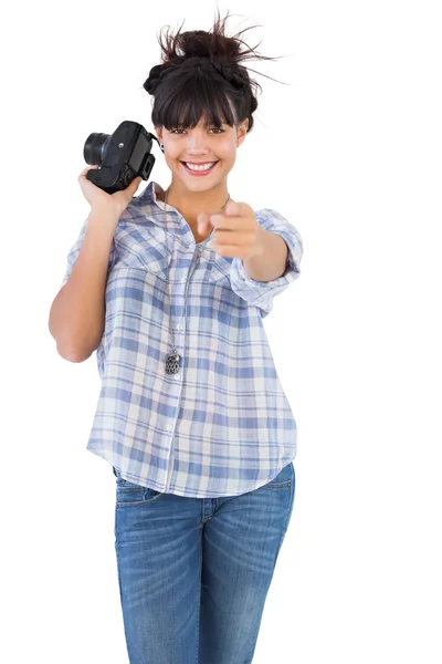 Sorrindo mulher segurando câmera e apontando o dedo — Fotografia de Stock