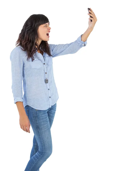 Morena furiosa segurando seu telefone celular e gritando — Fotografia de Stock