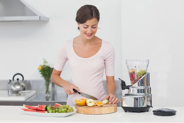 Donna incinta che taglia frutta in cucina — Foto Stock