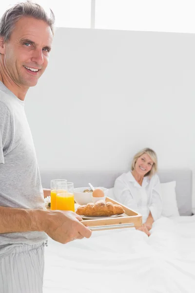 Homem feliz trazendo café da manhã na cama para seu parceiro — Fotografia de Stock