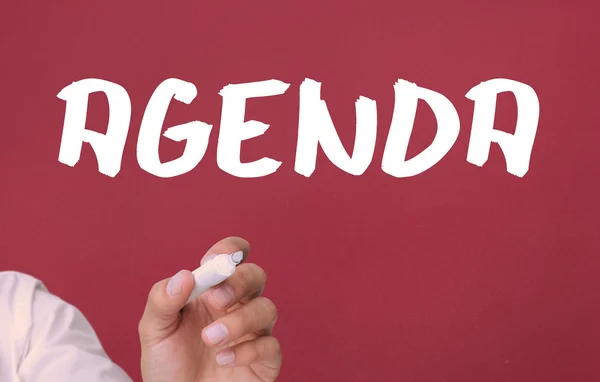 Businessman holding a marker and writing the word agenda — Stock Photo, Image