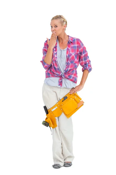 Surprised young woman wearing tool belt — Stock Photo, Image