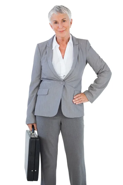 Businesswoman holding briefcase and putting her hand on hip — Stock Photo, Image