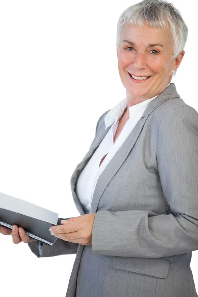 Mujer de negocios sonriente sosteniendo bloc de notas — Foto de Stock