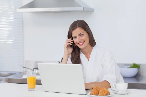 Telefon etmek ve bir dizüstü bilgisayar kullanarak bir kadın — Stok fotoğraf