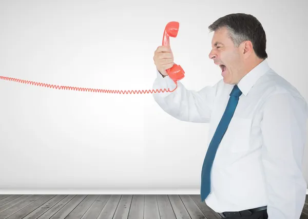 Empresario sosteniendo un teléfono y gritando — Foto de Stock