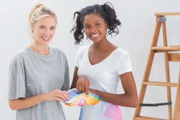 Les jeunes colocataires choisissent la couleur pour le mur et regardent la caméra — Photo