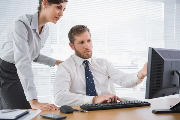 Бизнесмен показывает коллеге что-то на компьютере — стоковое фото
