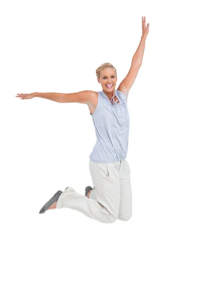 Blond kvinna hoppa med händer upp i luft — Stockfoto