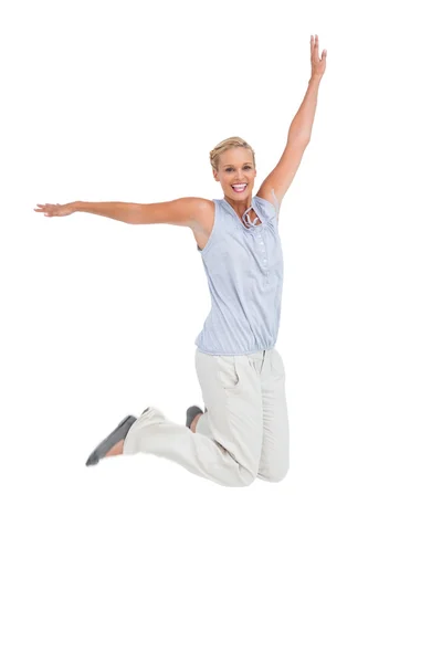 Blonde woman jumping with hands up in air — Stock Photo, Image