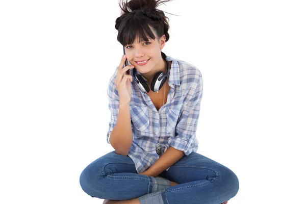 Jeune femme assise par terre avec des écouteurs appelant quelqu'un — Photo