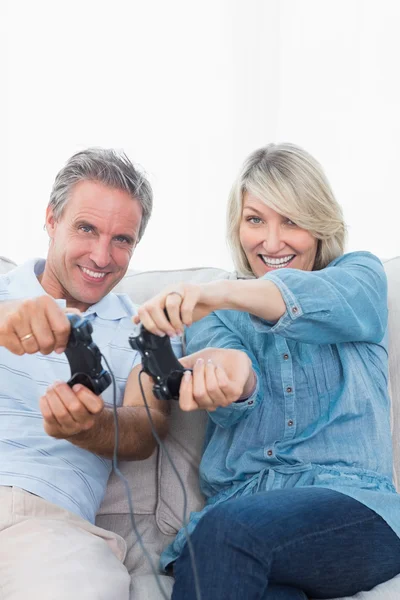 Casal jogando jogos de vídeo juntos no sofá — Fotografia de Stock