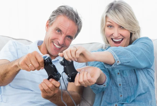 Casal jogando videogames no sofá — Fotografia de Stock