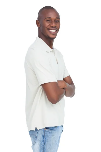 Sorridente giovane uomo in piedi con le braccia incrociate — Foto Stock