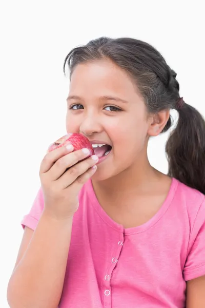 Smiling little girl eating apple — Stock Photo, Image