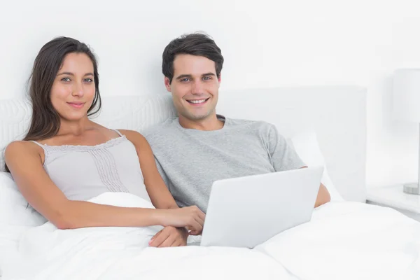 Portrait of a cheerful couple using a laptop — Stock Photo, Image