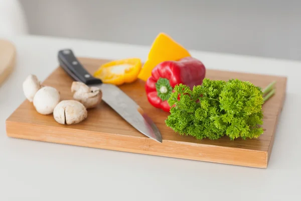 Placa de corte em uma cozinha com pimenta vermelha e amarela — Fotografia de Stock