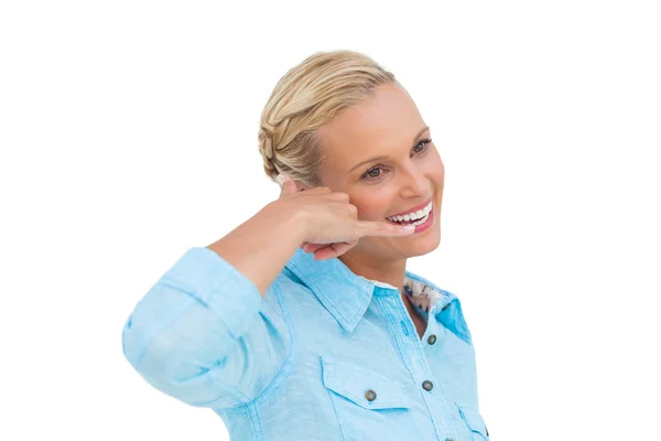 Aantrekkelijke blonde doet een symbool van telefoon met haar hand en look — Stockfoto