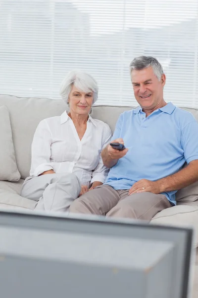 Casal assistindo televisão no sofá — Fotografia de Stock