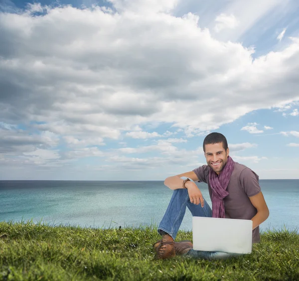 Przystojny mężczyzna siedzi na trawie — Zdjęcie stockowe