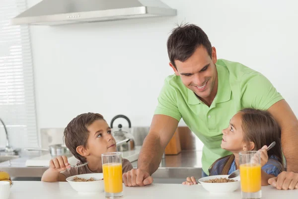 Father talking to his children while they are having breakfast — Stock Photo, Image