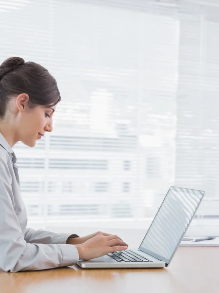 Businesswoman typing on her laptop at desk — Stock Photo, Image