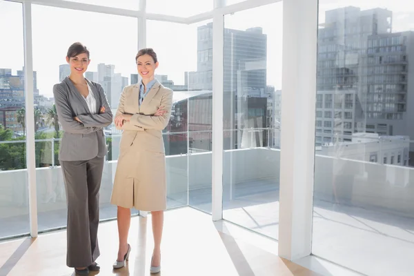 Smiling businesswomen standing in bright office — Stock Photo, Image