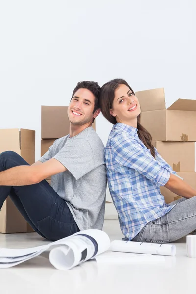 Happy couple sitting back to back — Stock Photo, Image