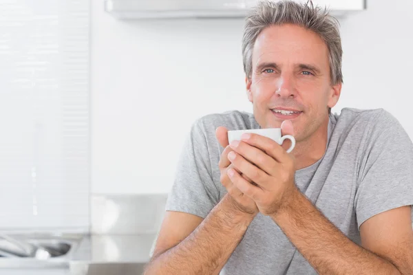 Homem feliz tomando café na cozinha — Fotografia de Stock