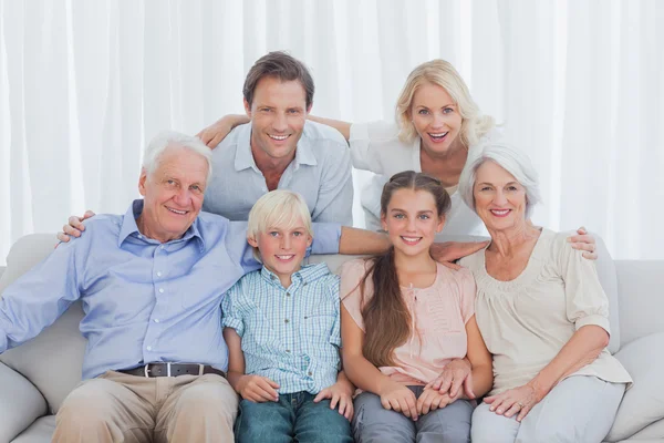 Família estendida sentados juntos no sofá — Fotografia de Stock