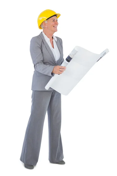 Smiling architect with plan wearing hardhat — Stock Photo, Image