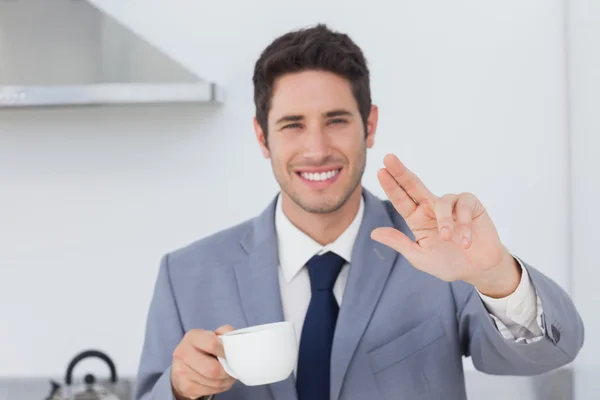 Cheerful businessman waving at someone in the kitchen — Stock Photo, Image