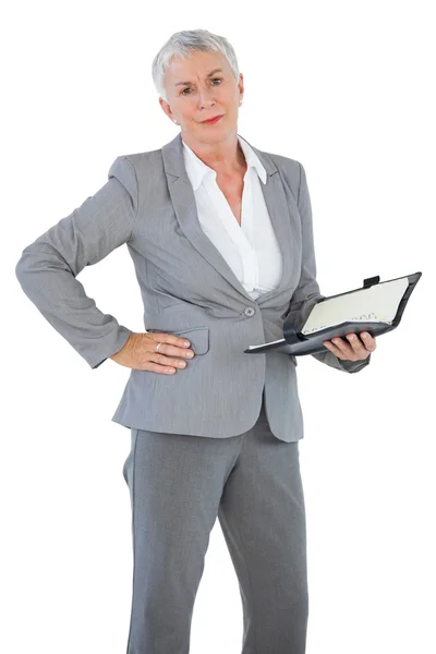 Businesswoman holding diary with her hand on hip — Stock Photo, Image