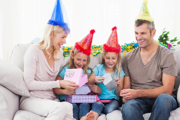 Gemelos desenvolviendo regalo de cumpleaños con sus padres — Foto de Stock