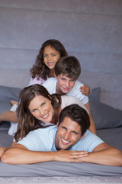 Família feliz brincando juntos na cama — Fotografia de Stock