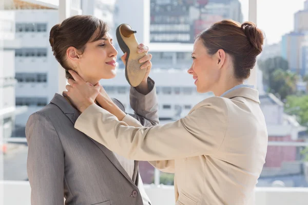 Businesswoman strangling another who is defending with her shoe — Stock Photo, Image