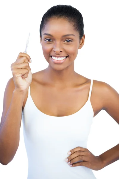 Happy woman with her hand on hip holding tweezers — Stock Photo, Image