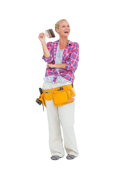 Woman standing while holding a paint brush — Stock Photo, Image