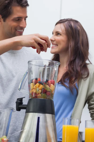 Man sätter frukt i mixer — Stockfoto