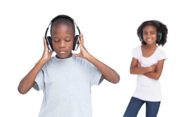 Little boy with eyes closed listening to music with his sister — Stock Photo, Image