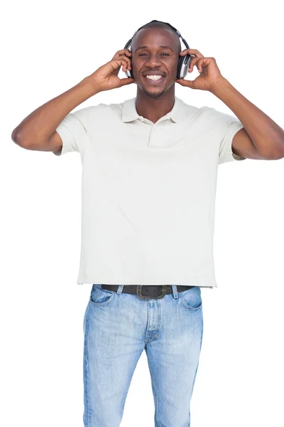 Homme souriant utilisant des écouteurs — Photo