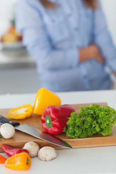 Placa de madeira com legumes em uma mesa de cozinha — Fotografia de Stock