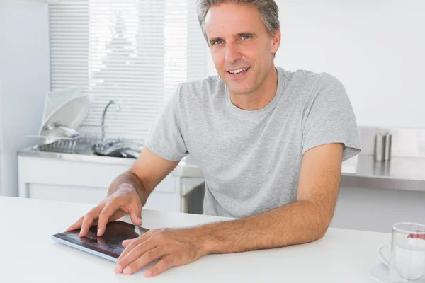 Hombre feliz usando tableta digital en la cocina — Foto de Stock