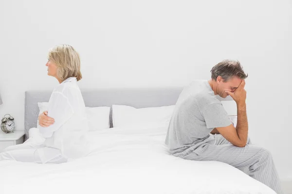 Casal sentado em lados opostos da cama — Fotografia de Stock