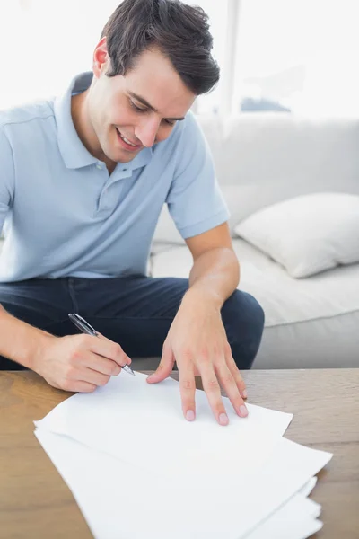 Homem alegre escrevendo em um papel — Fotografia de Stock