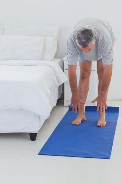 Man stretching on a mat Royalty Free Stock Images