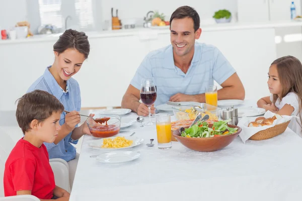 Familie isst Pasta und Salat lizenzfreie Stockbilder