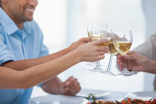 Close up of hands clinking glasses of white wine — Stock Photo, Image