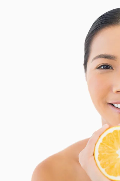 Das halbe Gesicht einer hübschen Frau mit Orange — Stockfoto