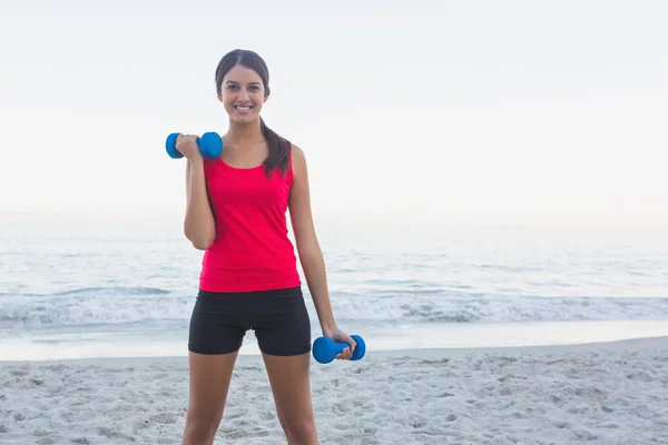 Mujer deportiva sonriente haciendo ejercicio con pesas — Foto de Stock